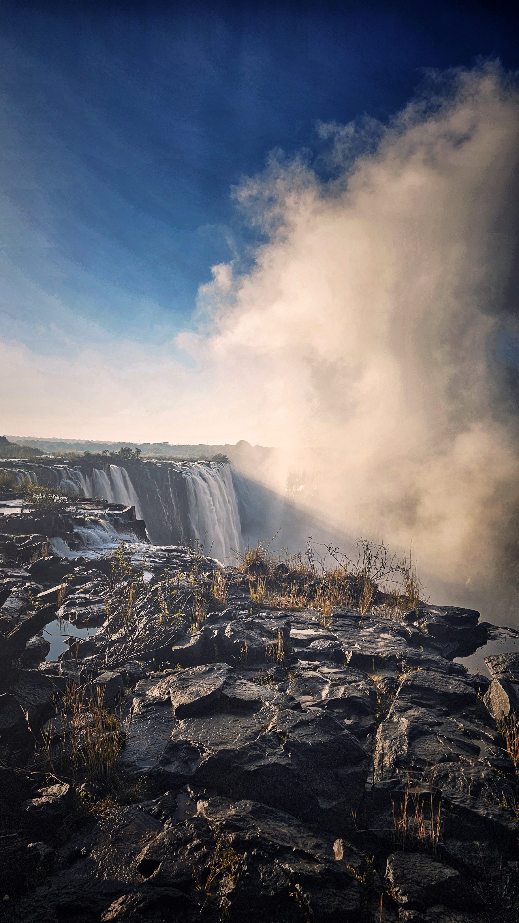 Krawędź Victoria Falls i unosząca się bryza w porannym świetle